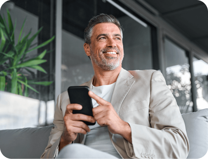 Customer relaxing on a couch while checking their smartphone, representing easy access to digital wallet passes for rewards, loyalty, or updates.