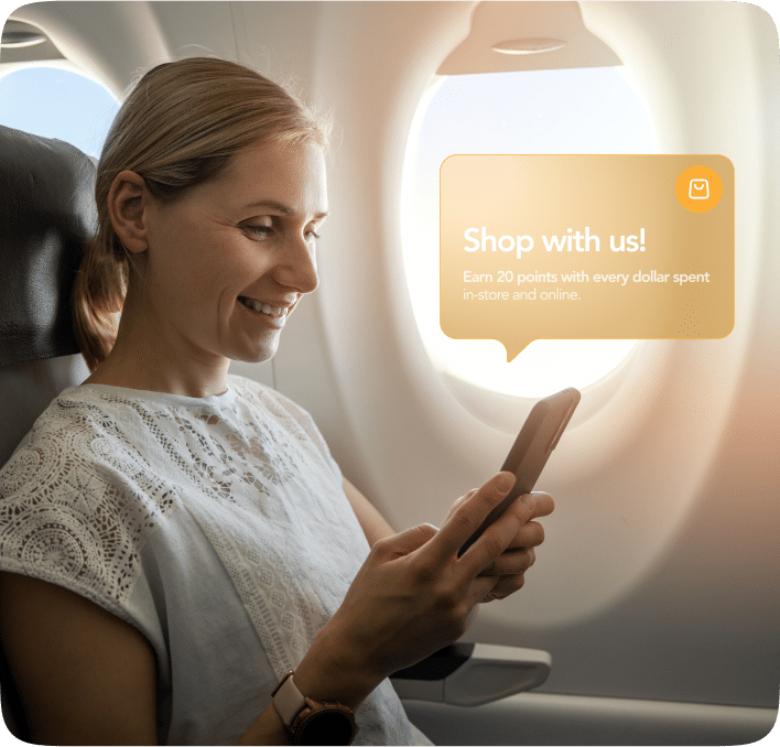 Customer using a smartphone while traveling, receiving a mobile wallet message about earning loyalty points, highlighting engagement beyond physical locations.