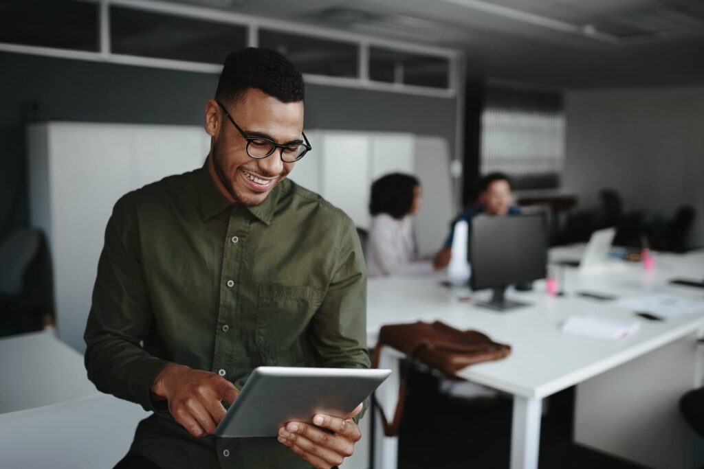 Employee reviewing analytics on a tablet in an office environment, representing real-time insights and performance tracking for a digital wallet loyalty or engagement program.