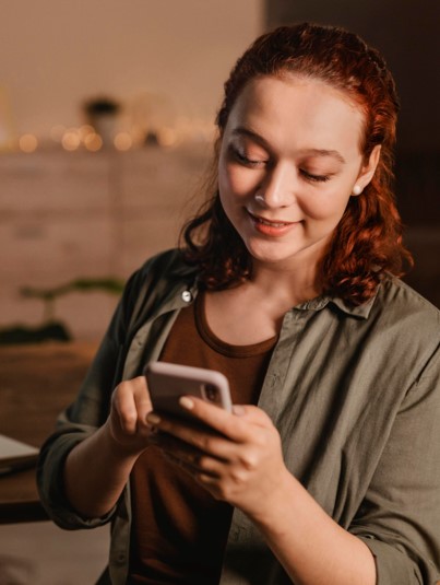 Customer smiling while using their smartphone, representing everyday interaction with digital wallet passes for rewards, updates, or personalized offers.