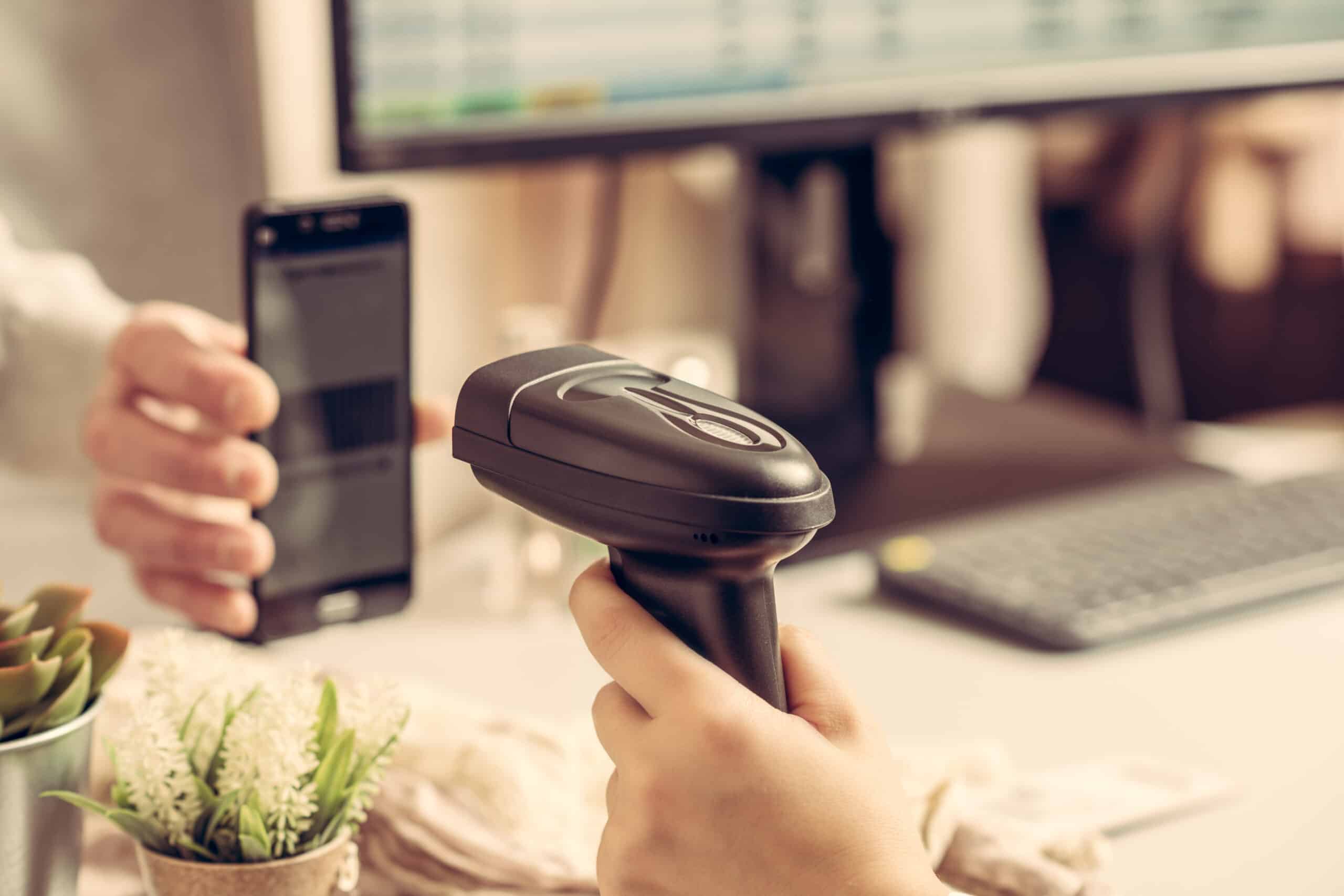Woman cashier scanning qr code from buyer phone using barcode scanner. Man buying a gift in a female clothing store using promo code.