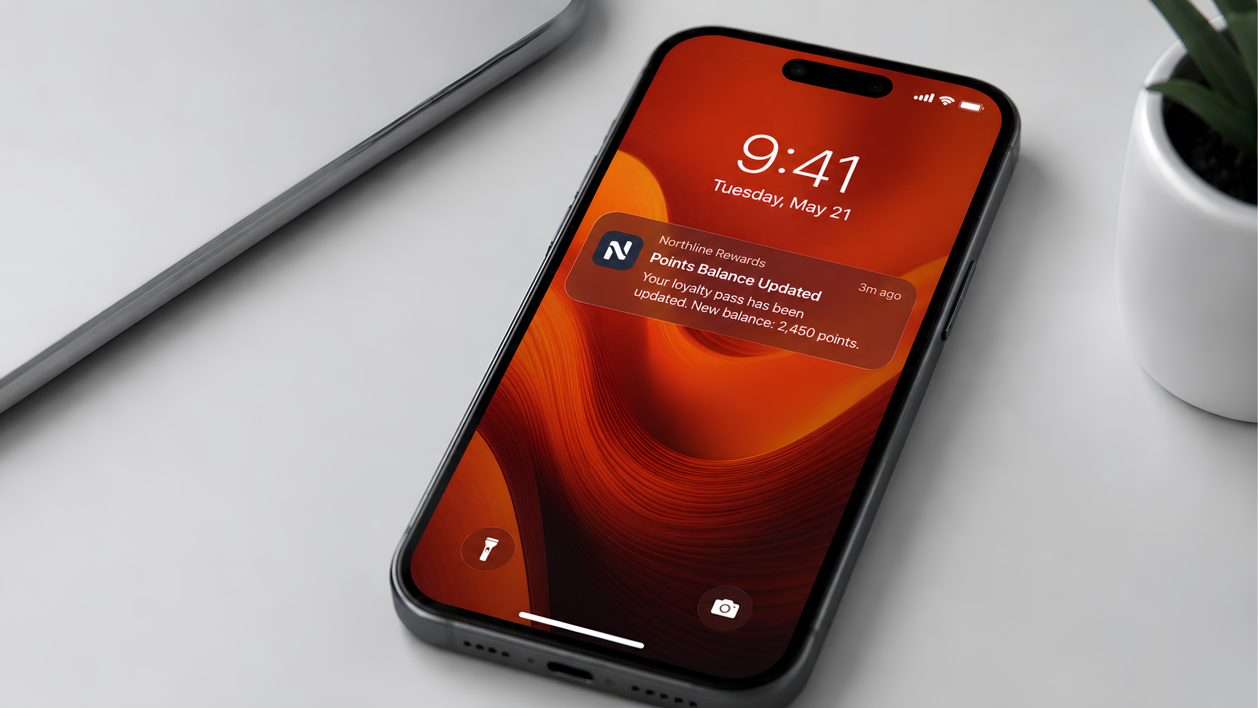 Smartphone on a desk showing a lock screen notification for an updated loyalty pass points balance.